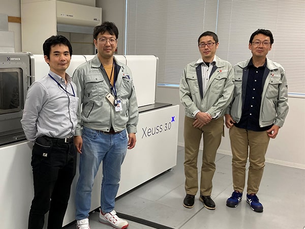 AIST researchers standing in front of the Xeuss 3.0 SAXS/WAXS instrument at Hiroshima, Japan, demonstrating multiscale structural analysis